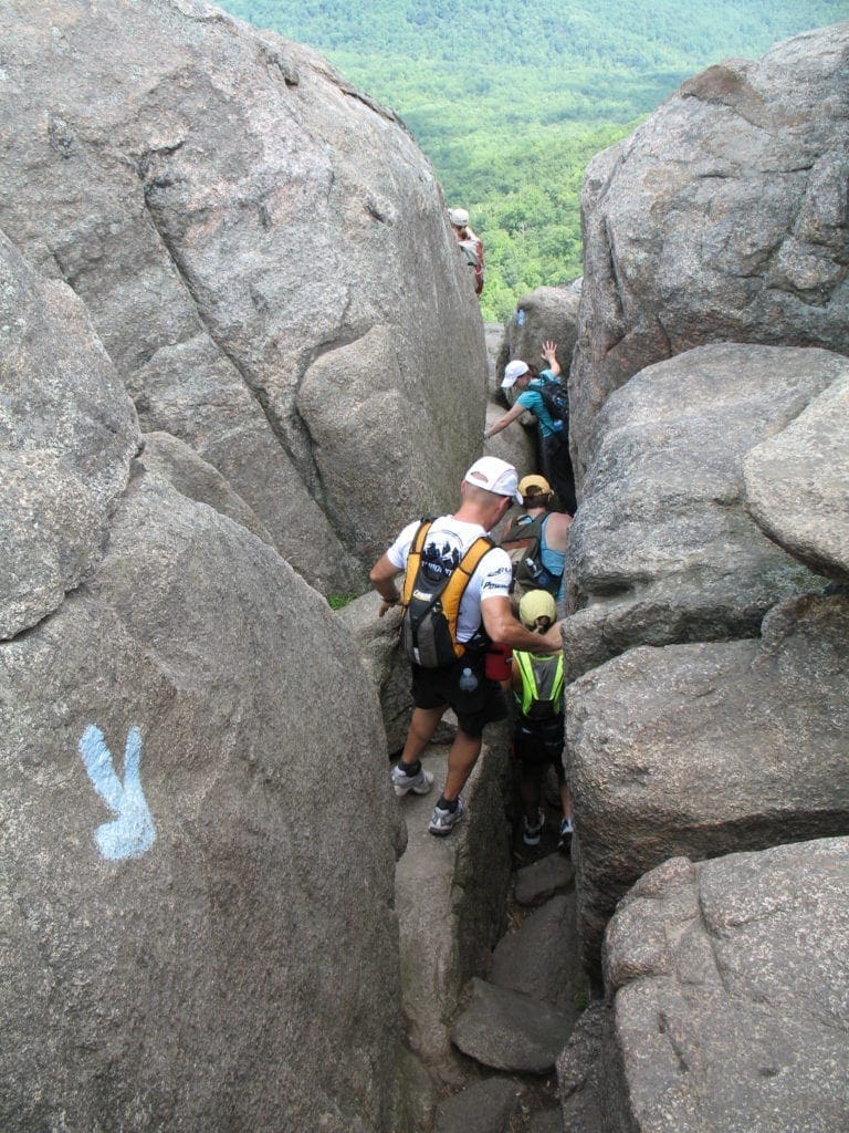 November 2020 - Park of the Month 10 Hikers walk down a narrow rock rift on Old Rag