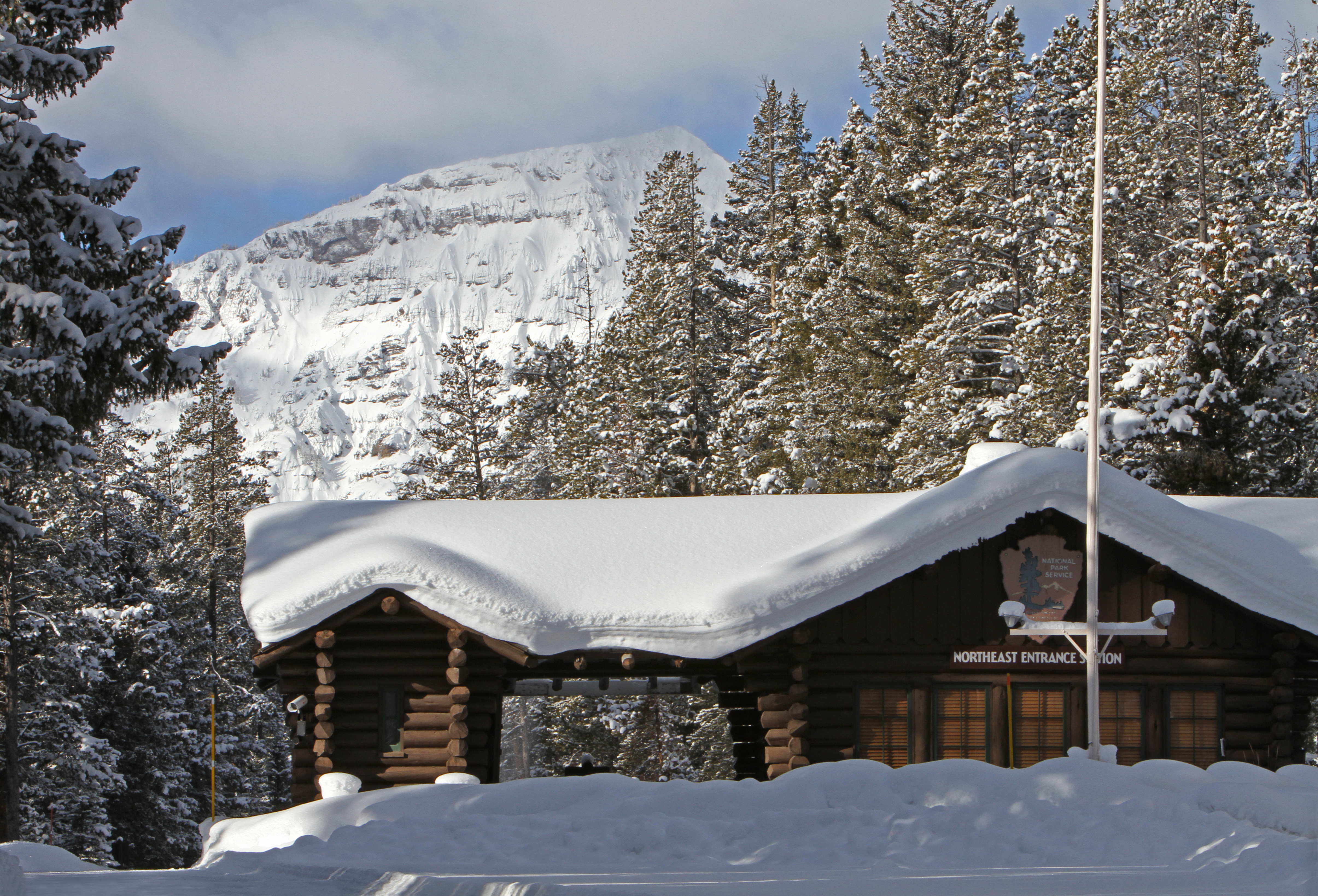 Winter in the Parks 6 Northeast Entrance in winter with snow on the building with mountains and trees in the background