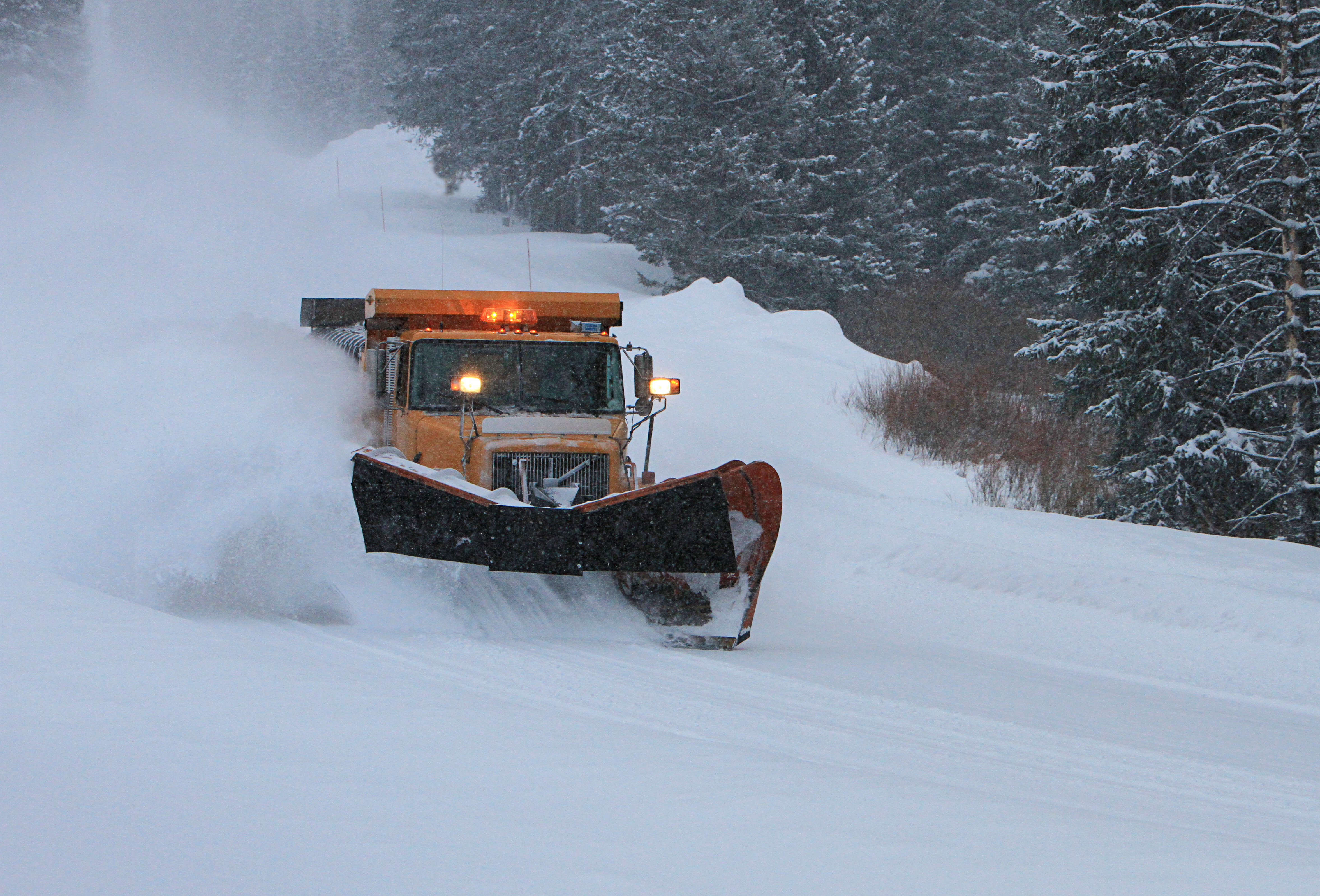 Winter in the Parks 8 Snow plow on snowy road with forests surrounding it.