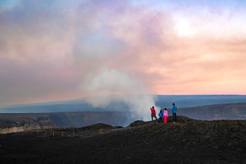 January 2021 - Park of the Month 7 A family watches a plume of gas and steam rise from Kīlauea just after sunrise from the Keanakākoʻi viewing area.
