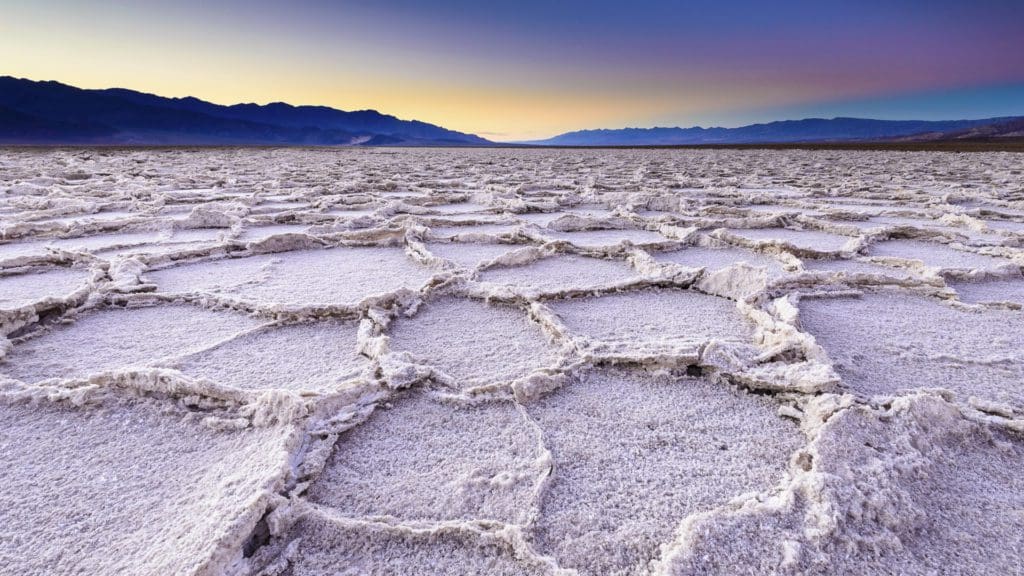 March 2021 - Park of the Month 17 A crusty basin salt flat at sunset with the mountains silhouetted in the distance