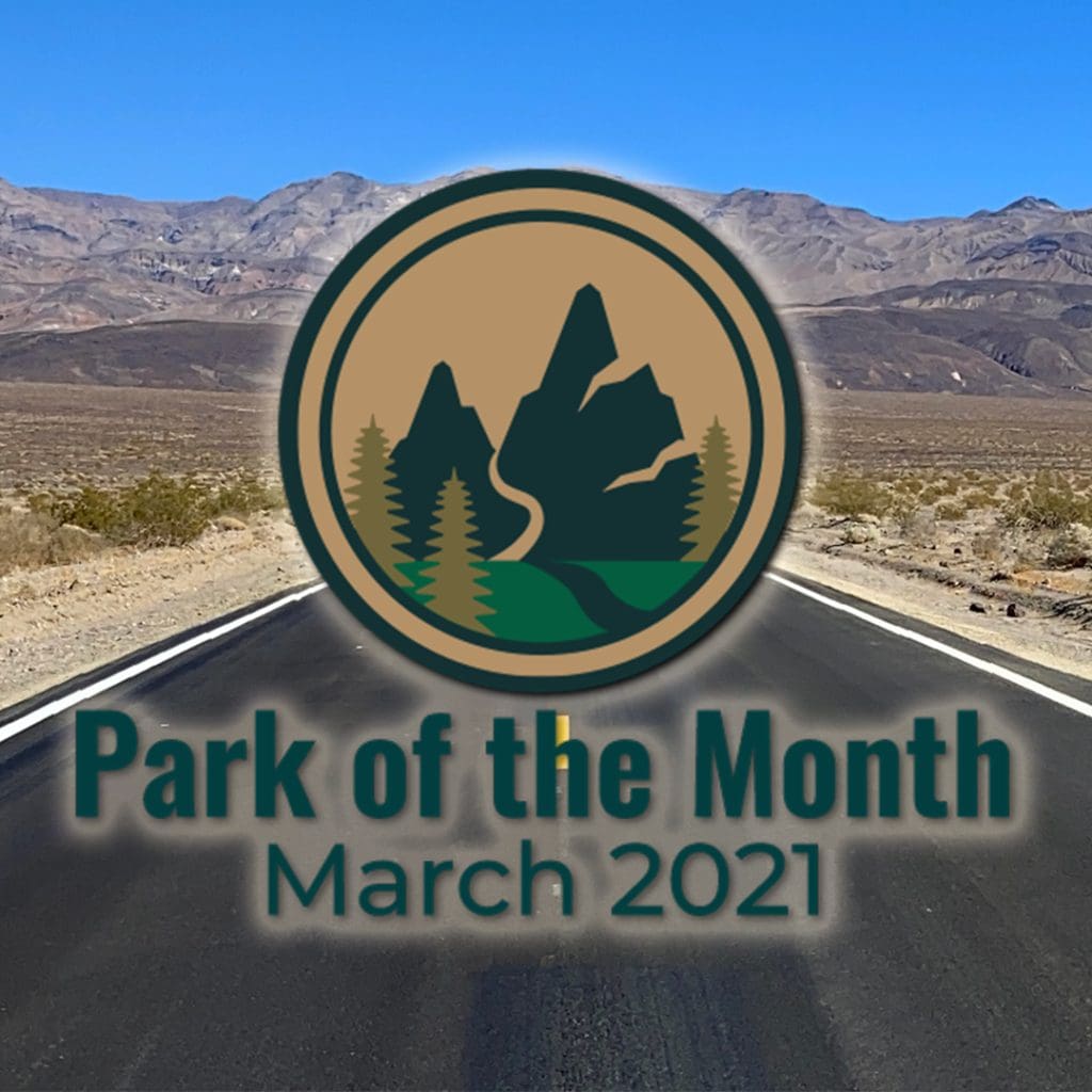 A road runs through the dessert into the mountains in the distance in Death Valley National Park, California